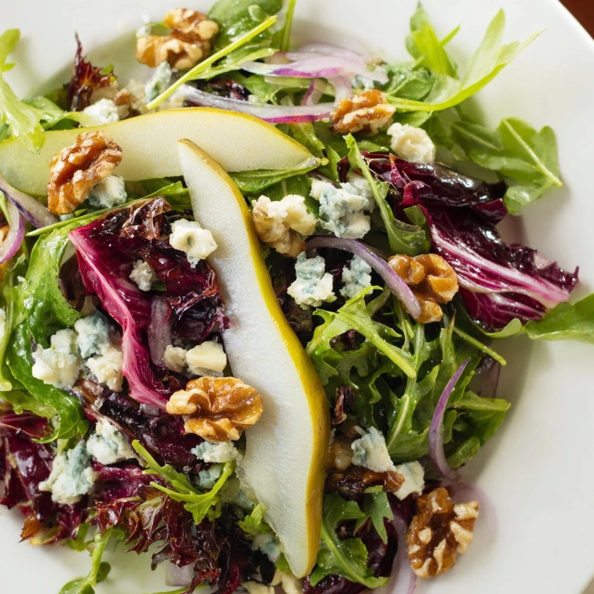 Crisp winter greens topped with sweet pear slices and shiny candied walnuts, drizzled with tangy vinaigrette.