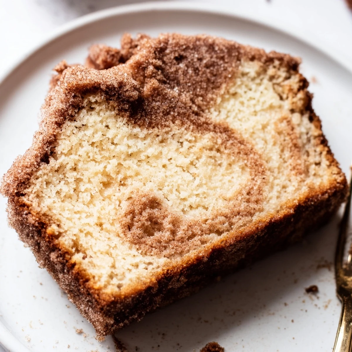 Freshly baked Sugar-Crusted Vanilla Loaf Cake cooling on a wire rack, showcasing its golden crust and tender crumb.