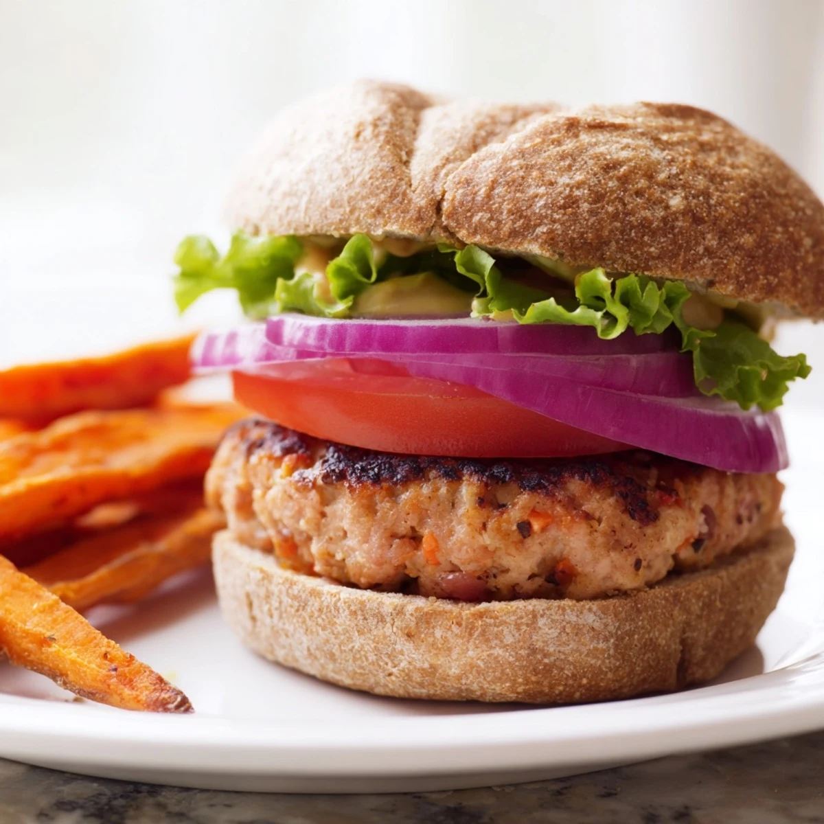 Freshly baked sweet potato fries seasoned with smoked paprika and garlic powder paired with a perfectly cooked turkey burger on a toasted bun.