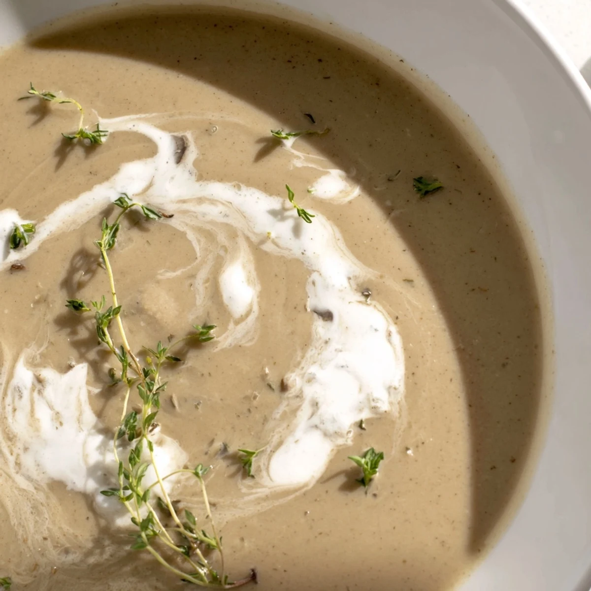 Creamy Mushroom Soup with Thyme served steaming hot in a rustic bowl, garnished with fresh thyme leaves and black pepper.