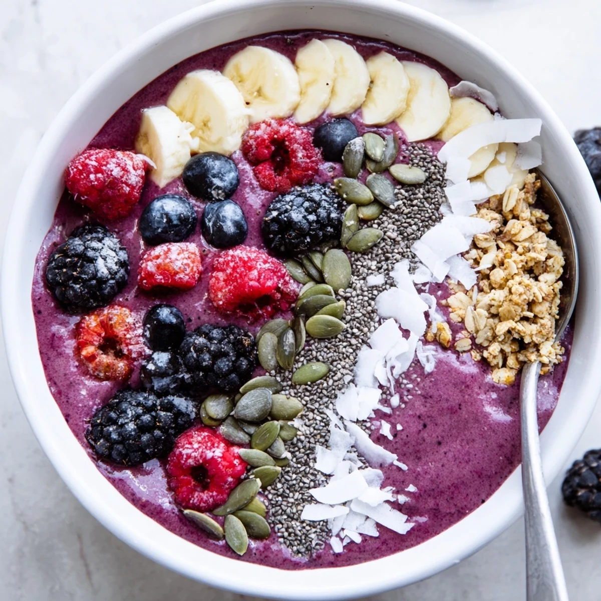 Spoon-ready Winter Berry Smoothie Bowl with Seeds features layers of frozen berries and a generous topping of nutritious seeds.