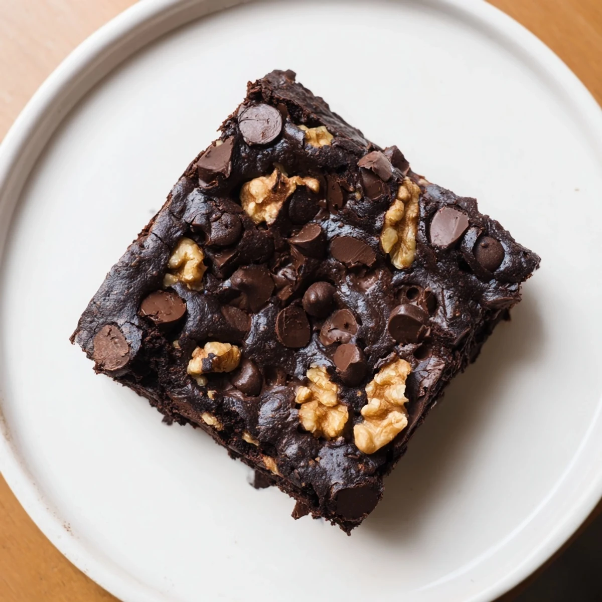 Homemade chocolate fudge brownies with walnuts, cut into squares and served on a rustic wooden board, ready for a dessert party.