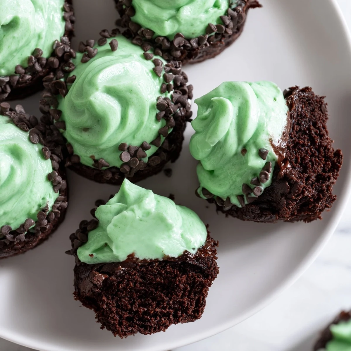 Festive St. Patricks Day Mint Brownie Bites with rich chocolate and cool mint flavor, topped with creamy green frosting.