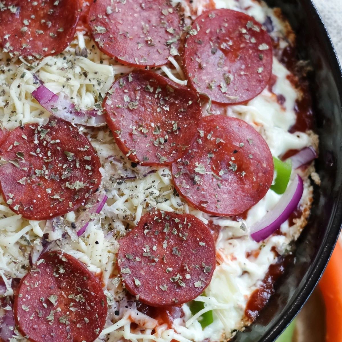A golden, bubbly Game Day Pepperoni Pizza Dip with melted mozzarella and Parmesan in a baking dish.