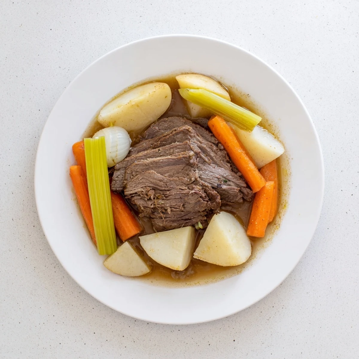 Slow Cooker Beef Pot Roast with Root Vegetables in a ceramic dish, garnished with fresh thyme and rosemary sprigs.