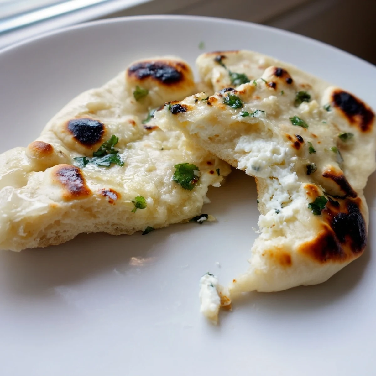 Golden-brown Cottage Cheese Garlic Naan fresh from the skillet, brushed with melted butter and herbs.