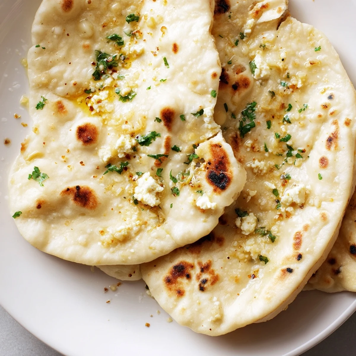 Soft, pillowy Cottage Cheese Garlic Naan stuffed with creamy filling, resting on a wooden board.