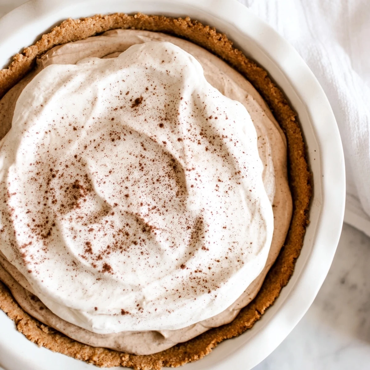 A creamy Keto Cold Brew Coffee Pie is served chilled with a fork beside it on a rustic table.