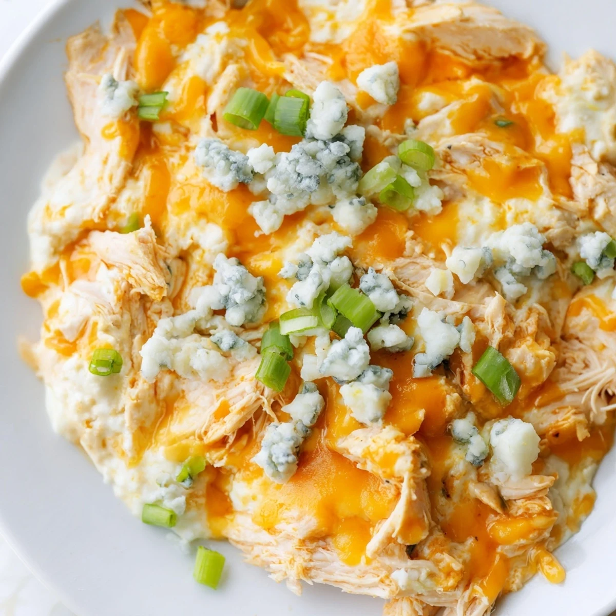 This Keto Buffalo Chicken Dip is garnished with fresh green onions and crumbled blue cheese for tangy flavor.