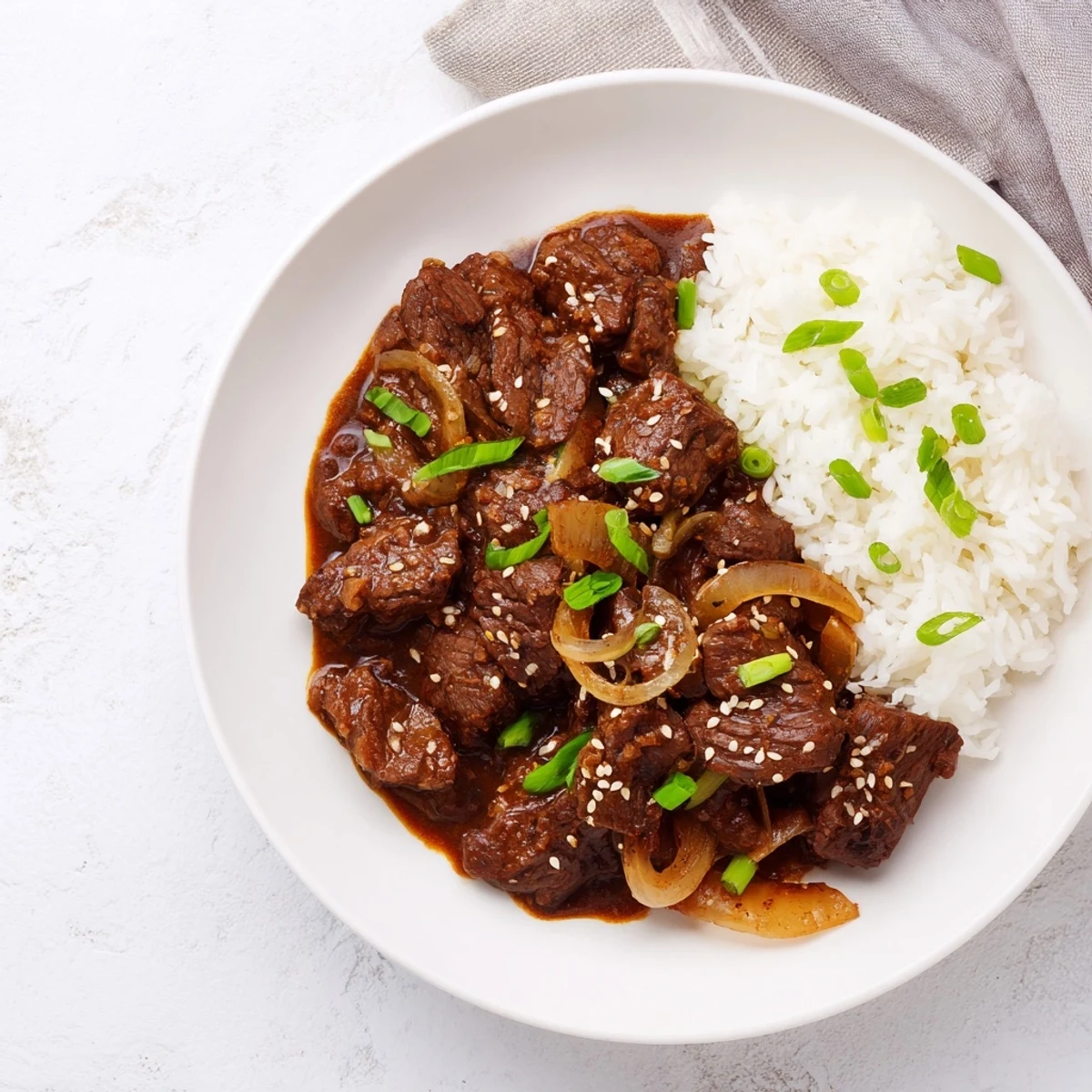 Crock Pot Korean Beef served in a white bowl over fluffy rice, with chopsticks ready for a comforting weeknight meal.