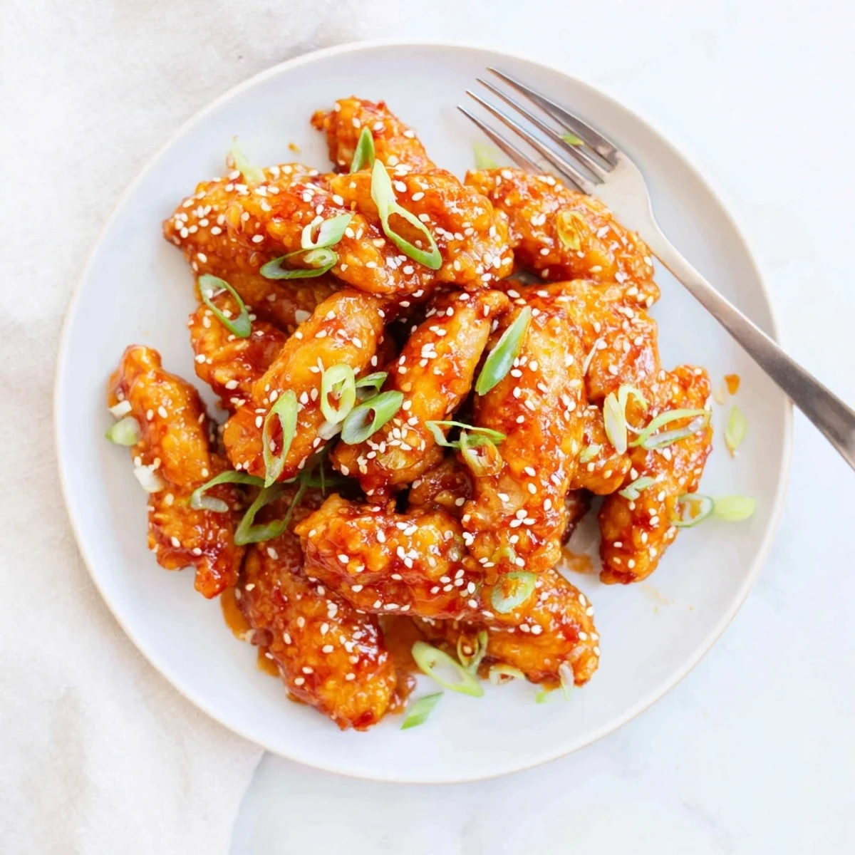 Close-up of succulent sticky orange chicken wings with garlic and ginger notes, arranged on a parchment-lined tray for game day.