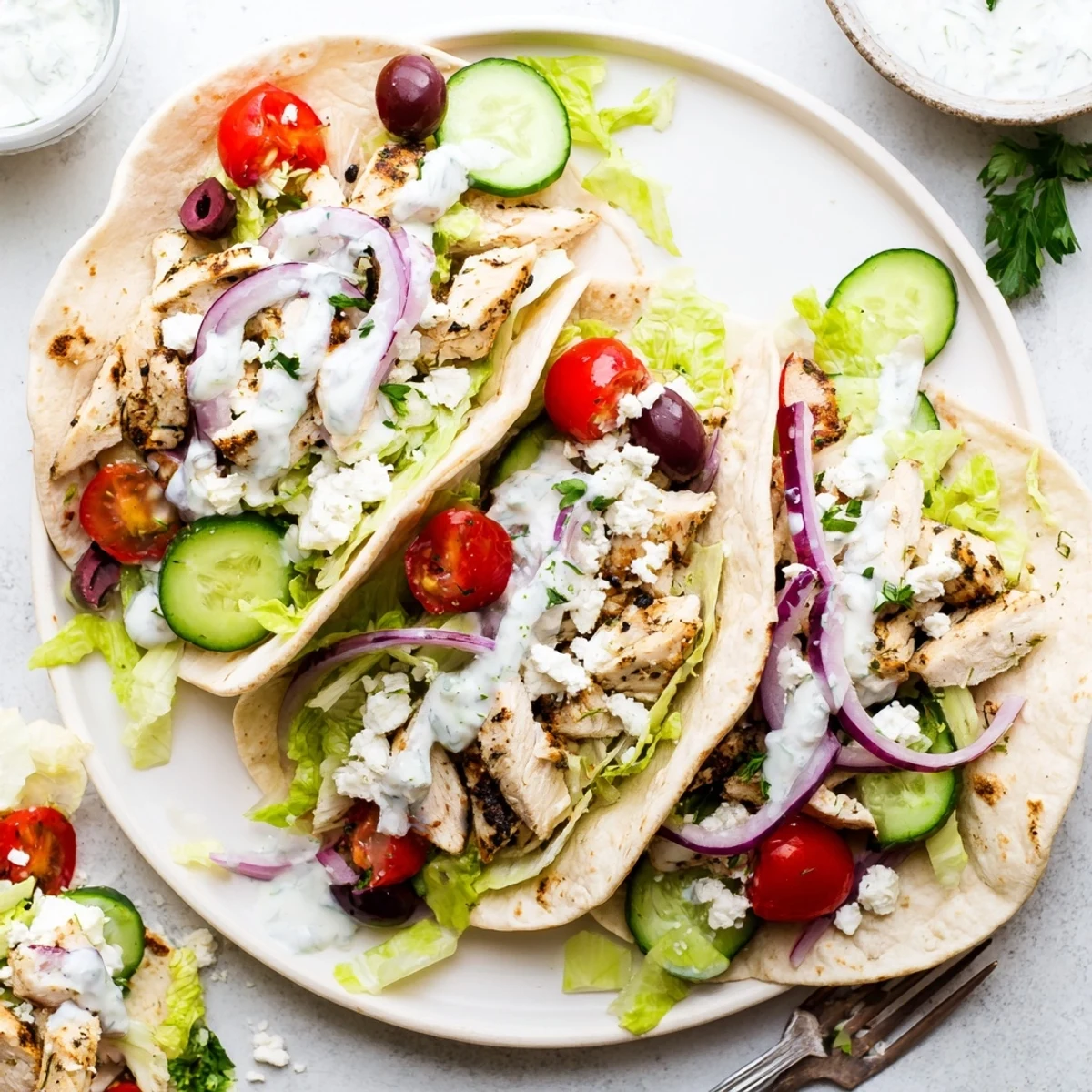 Delicious quick Mediterranean chicken tacos featuring seasoned meat, crunchy lettuce, and zesty white sauce