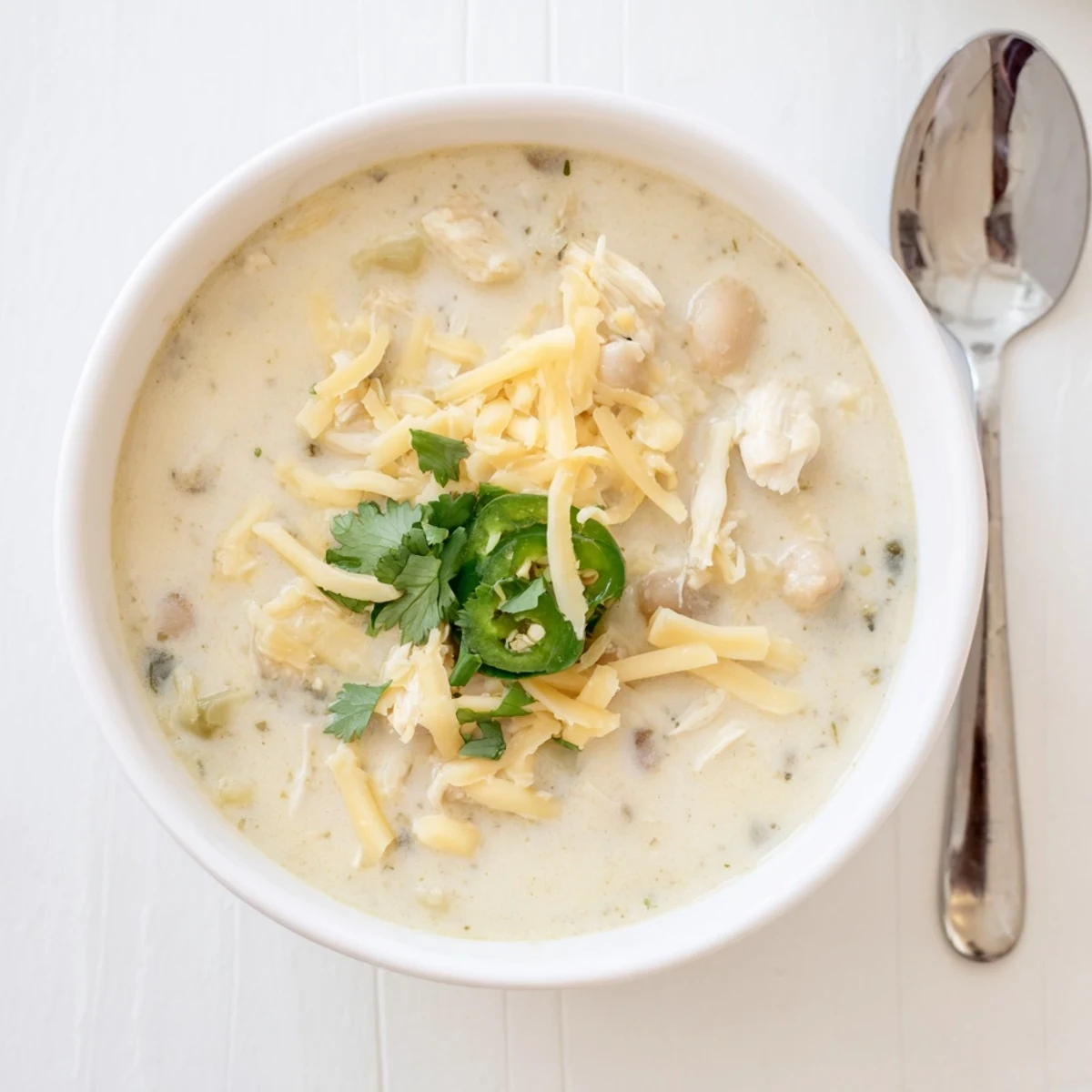 Rich and hearty simple keto white chicken chili garnished with lime wedges and green onions