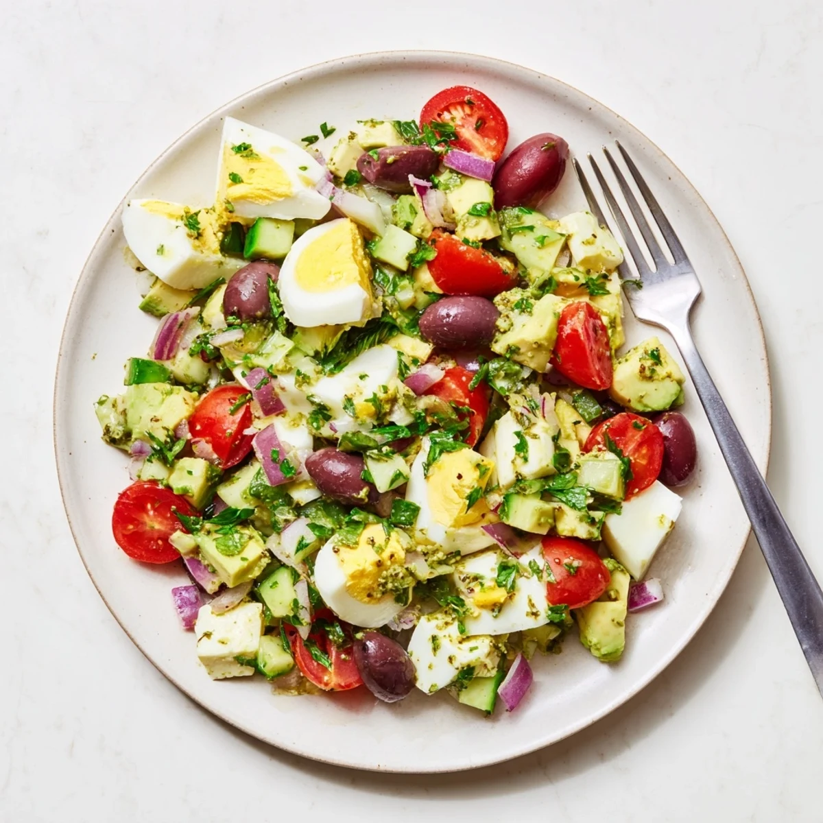 Protein-packed Mediterranean avocado egg salad with hard-boiled eggs, ripe avocado chunks, and vegetables served as a refreshing light lunch or side dish