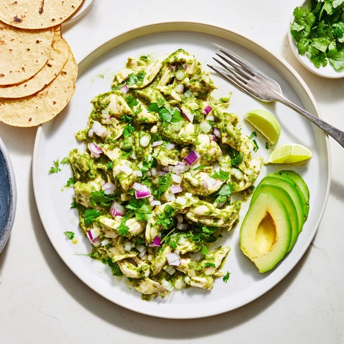 Golden chicken thighs simmered in vibrant green salsa verde, ready for warm corn tortilla tacos.