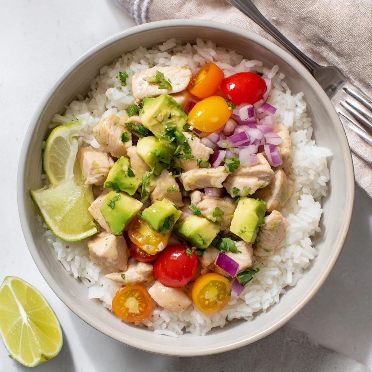 Sliced honey lime chicken breast served over fluffy white rice with creamy diced avocado and red onion