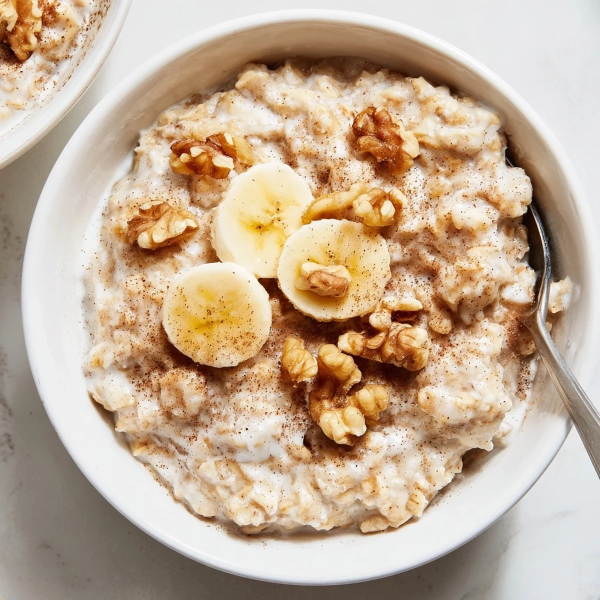 Glass jar layered with creamy brown sugar overnight oats topped with fresh banana slices and chopped walnuts