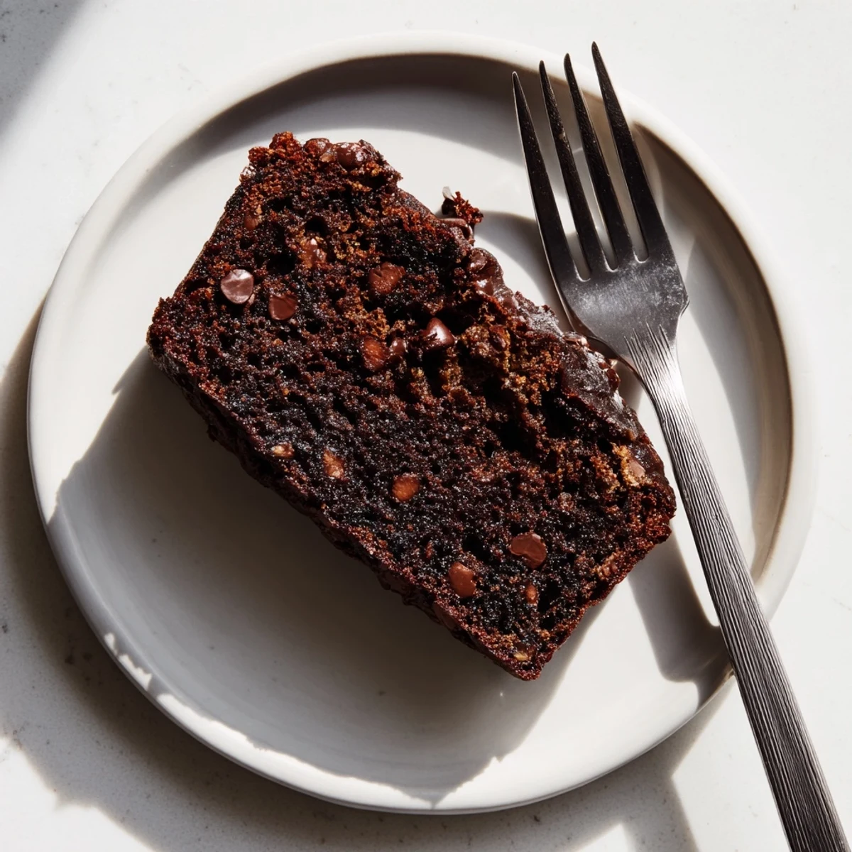 Freshly baked chocolate espresso banana bread loaf dusted with cocoa powder and served on a wire rack