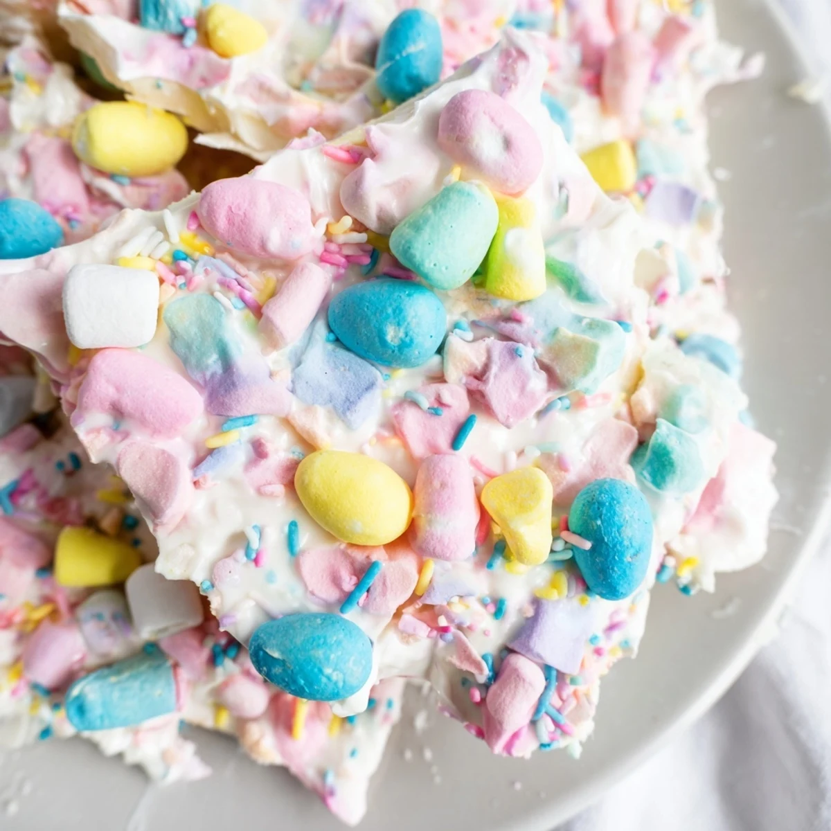 Creamy white chocolate Easter marshmallow bark topped with pastel sprinkles and candy eggs