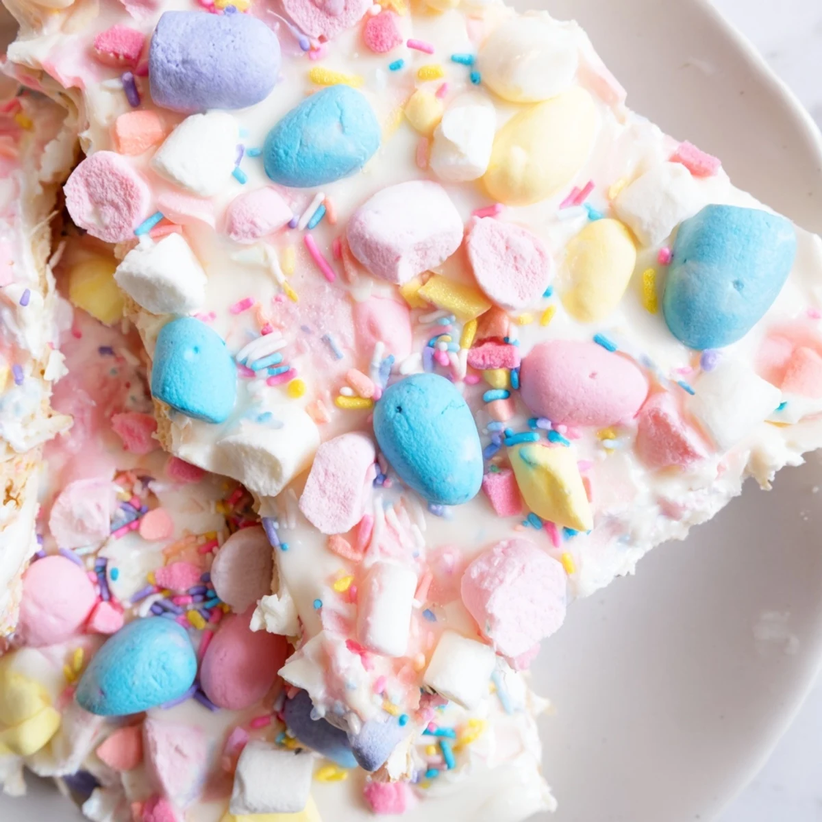 Festive Easter marshmallow bark scattered with pastel candy eggs and crunchy sprinkles