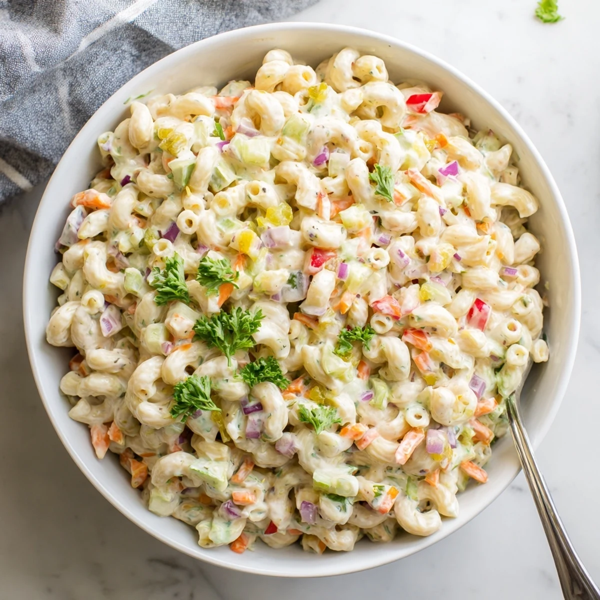 Creamy tangy macaroni salad loaded with colorful diced vegetables and coated in rich dressing