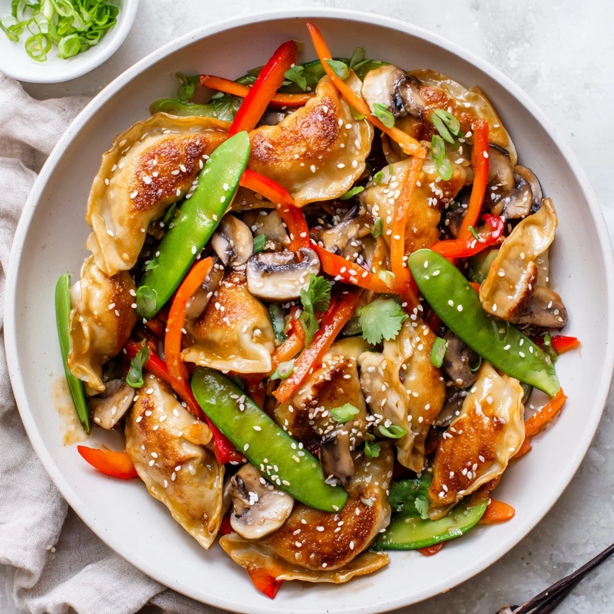Golden potsticker stir fry with colorful vegetables and savory soy sesame sauce in a large skillet