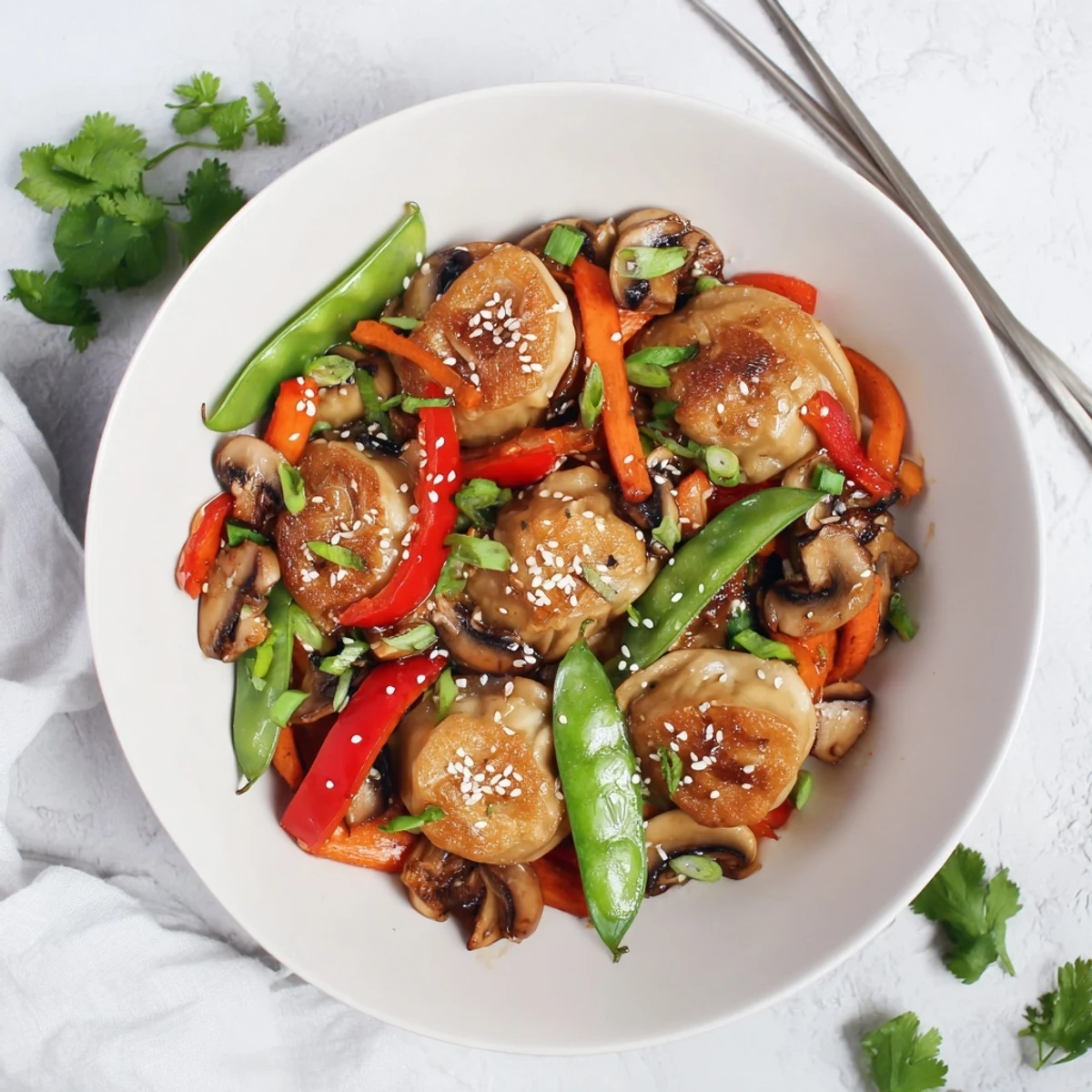 Crispy potstickers tossed with snap peas bell peppers and mushrooms in a glossy Asian fusion stir fry