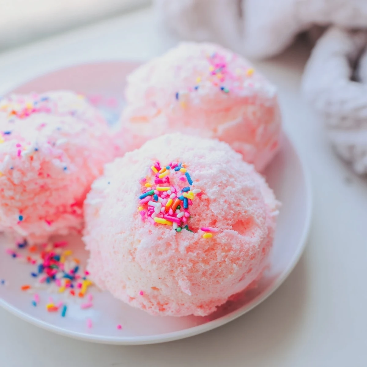 Mini Cotton Candy Cheesecake Puff Balls with fluffy pink spun sugar coating on a white platter
