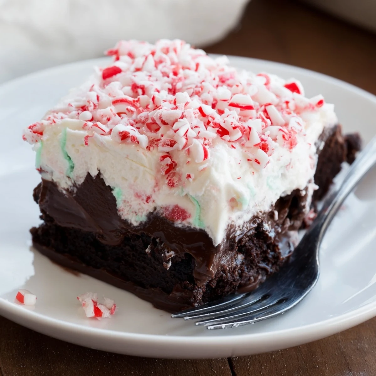 Slice of Peppermint Poke Cake showing minty pudding filling and chocolate chips
