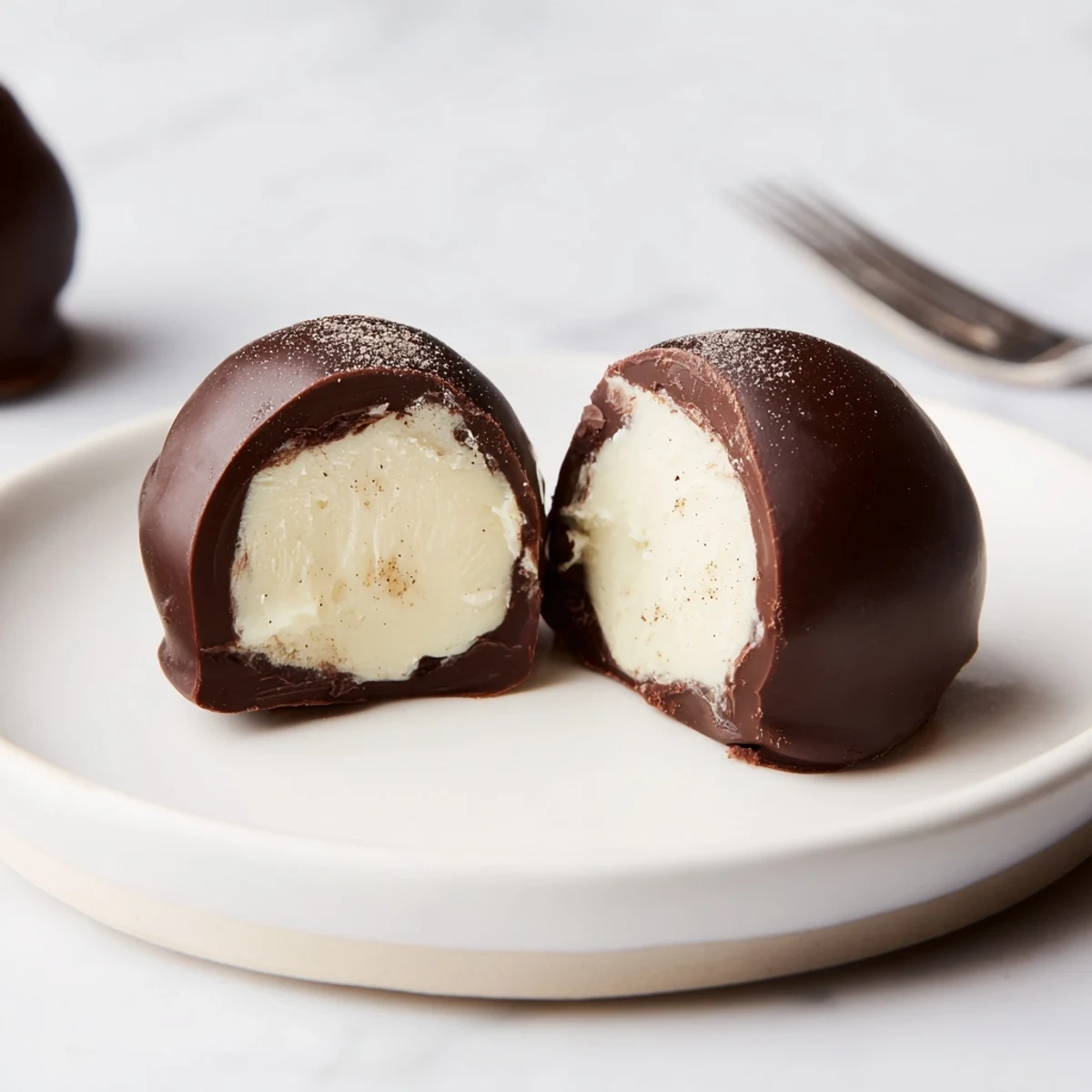 Hand-rolled Dark Chocolate Eggnog Truffles chilled, creamy centers peeking through cracked coating