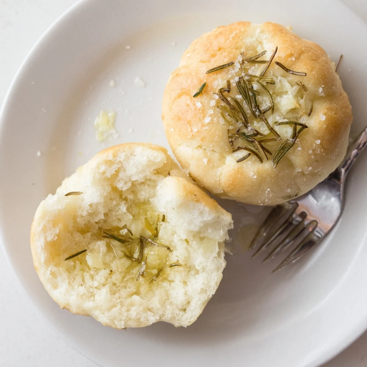 Glistening Garlic Rosemary Focaccia Muffins brushed with olive oil, flaky salt.