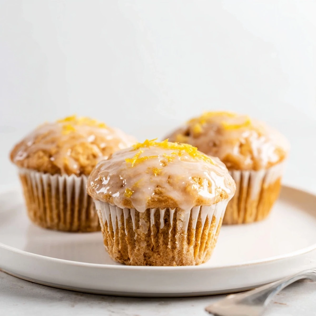 Fresh Glazed Lemon Ginger Muffins on wire rack, zesty aroma inviting  