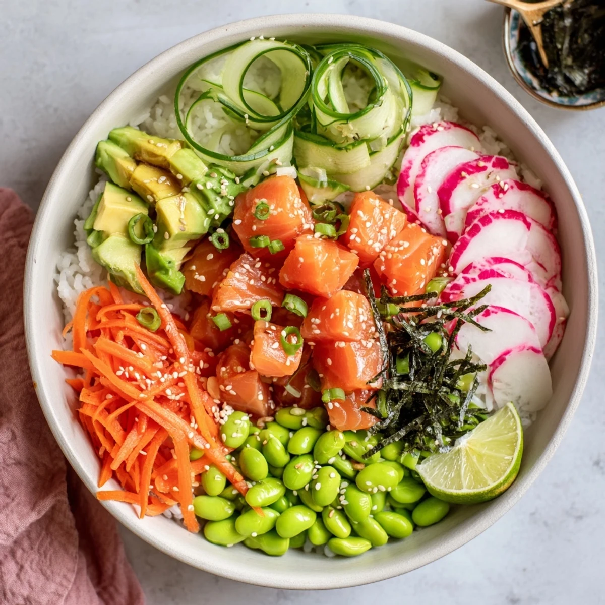 Colorful salmon and avocado poke bowl with fresh vegetables over seasoned white rice