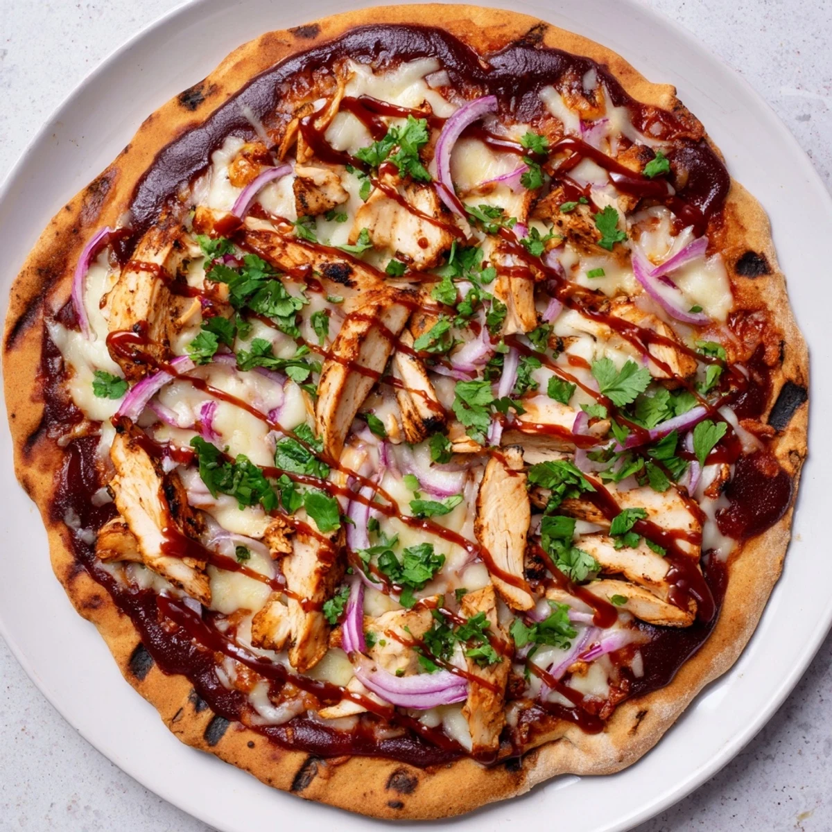 Smoky grilled BBQ chicken pizza featuring sliced chicken breast, tangy sauce, and bubbling gouda cheese on a crisp grilled base