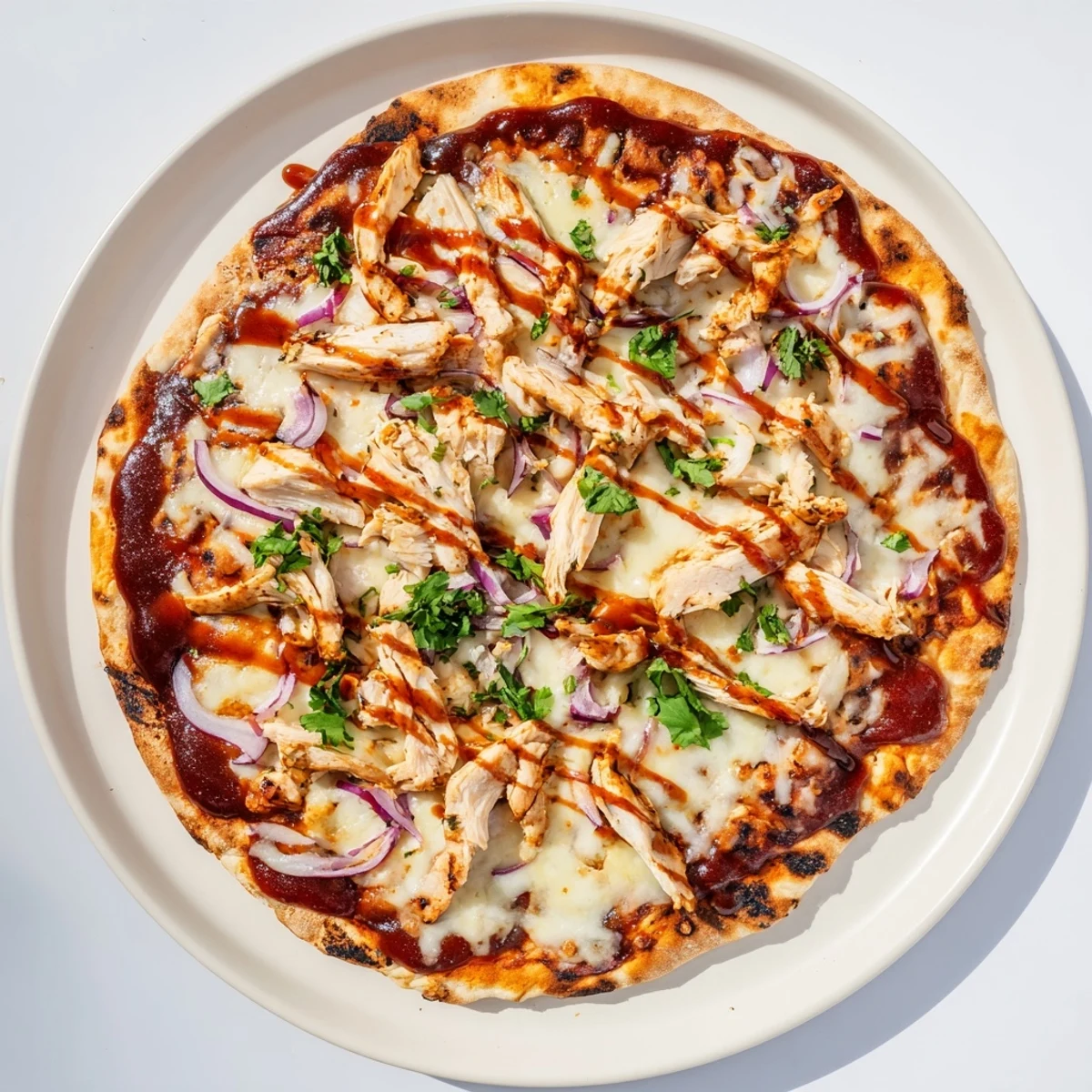 Golden grilled BBQ chicken pizza topped with melted mozzarella, red onions, and fresh cilantro on a charred crust