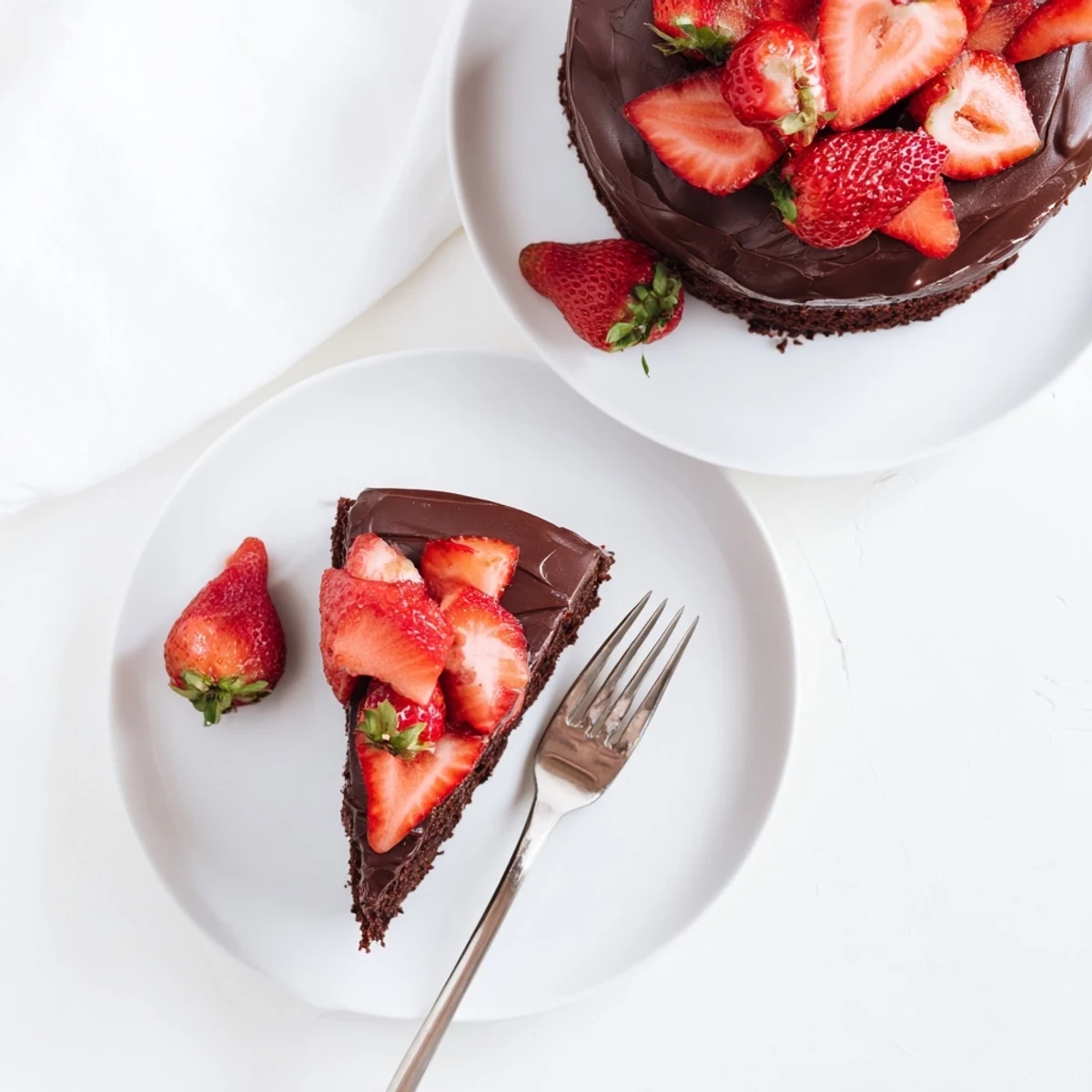Rich chocolate layer cake topped with juicy strawberries and velvety chocolate ganache frosting