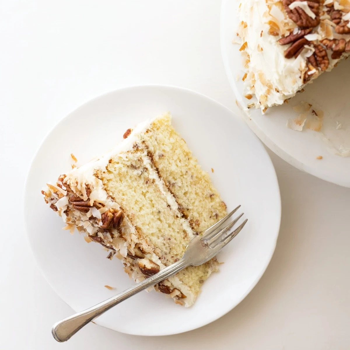 Moist Quick Italian Cream Cake slice showcasing coconut pecans and creamy cream cheese frosting