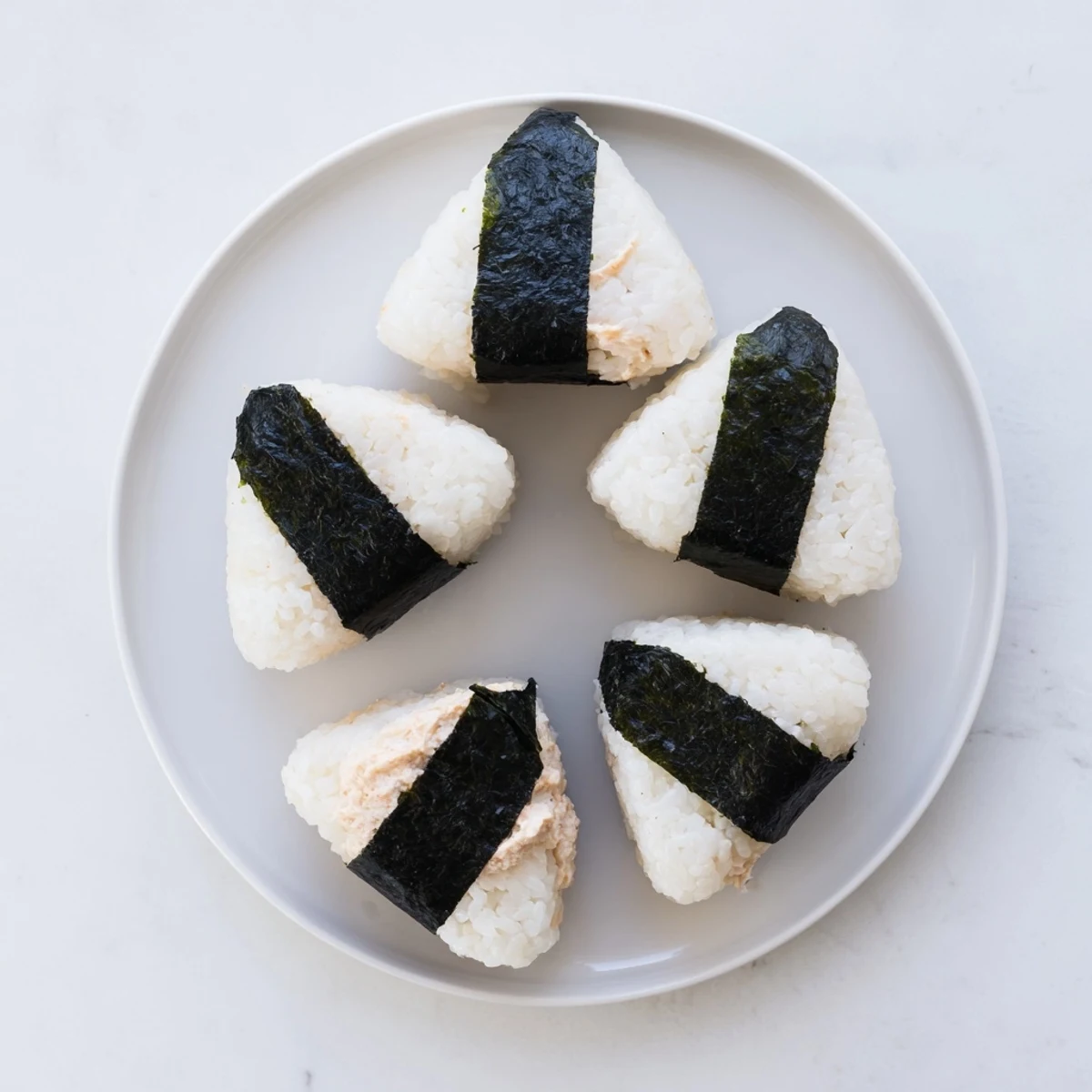 Triangular Japanese rice ball stuffed with creamy tuna mayonnaise and black sesame