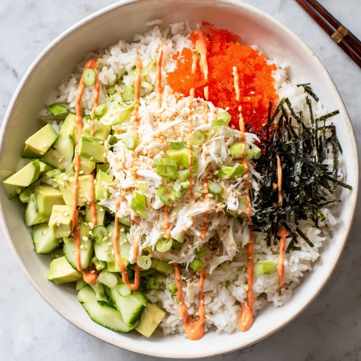 Colorful California Roll sushi bowl with fluffy rice, crab, avocado, cucumber, and sesame seeds