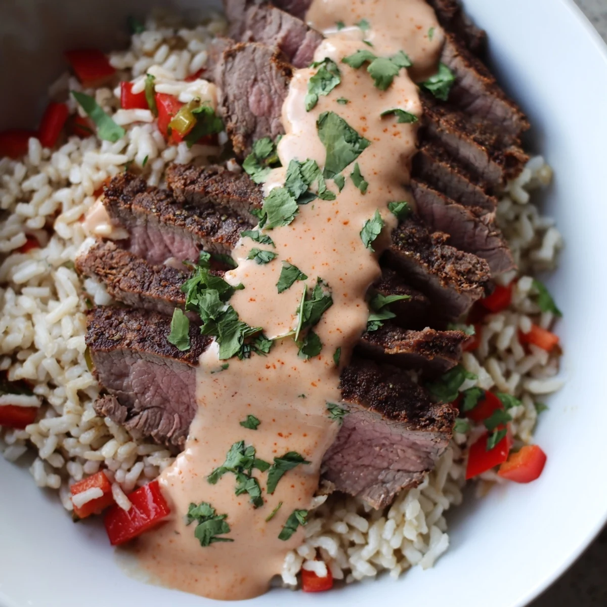 Golden steak queso rice served with warm queso and fresh cilantro garnish