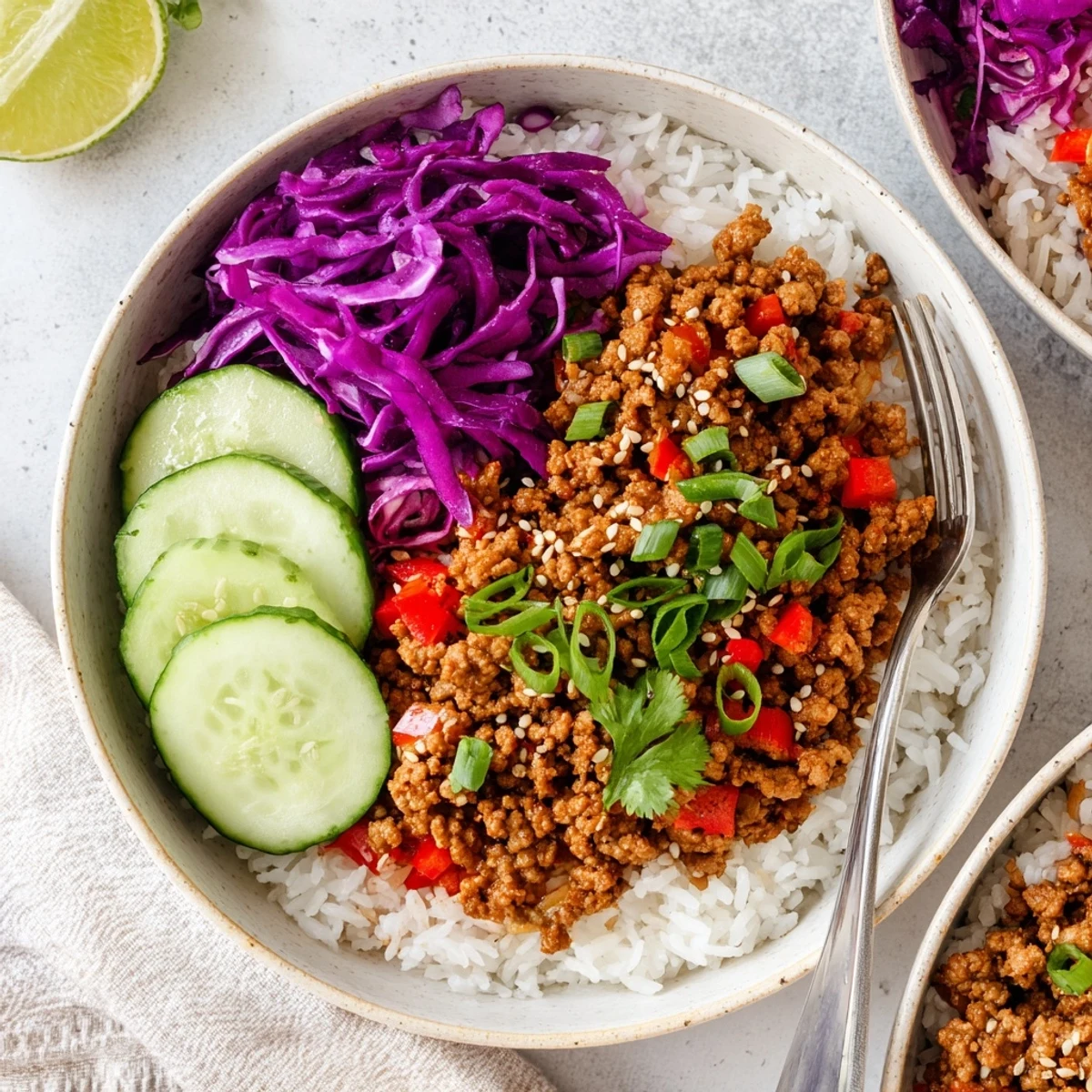 Hearty ground turkey rice bowls topped with crisp vegetables and toasted sesame seeds