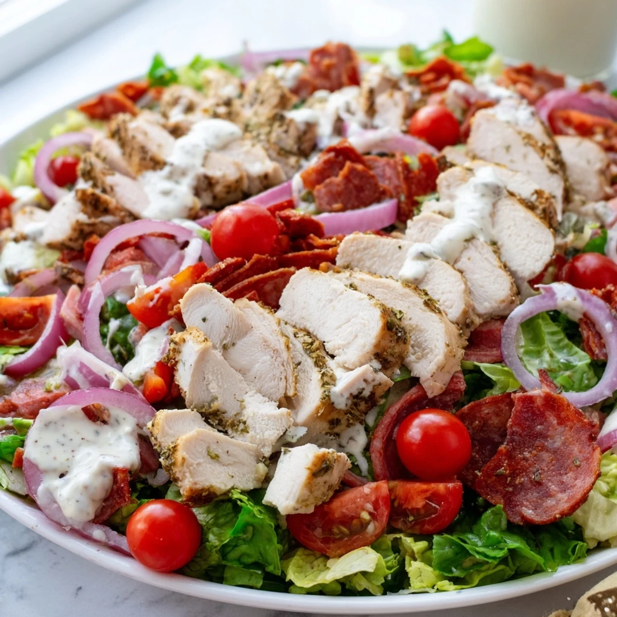 Italian Grinder Chicken Salad served in a bowl with provolone and pepperoncini