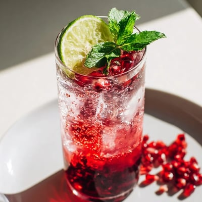 Two glasses of vibrant Pomegranate Fizz Mocktail, featuring sparkling water, tart pomegranate juice, and fresh lime.
